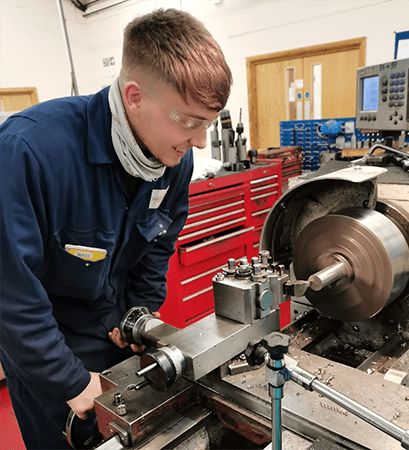 Machinist operating a lathe in the workshop