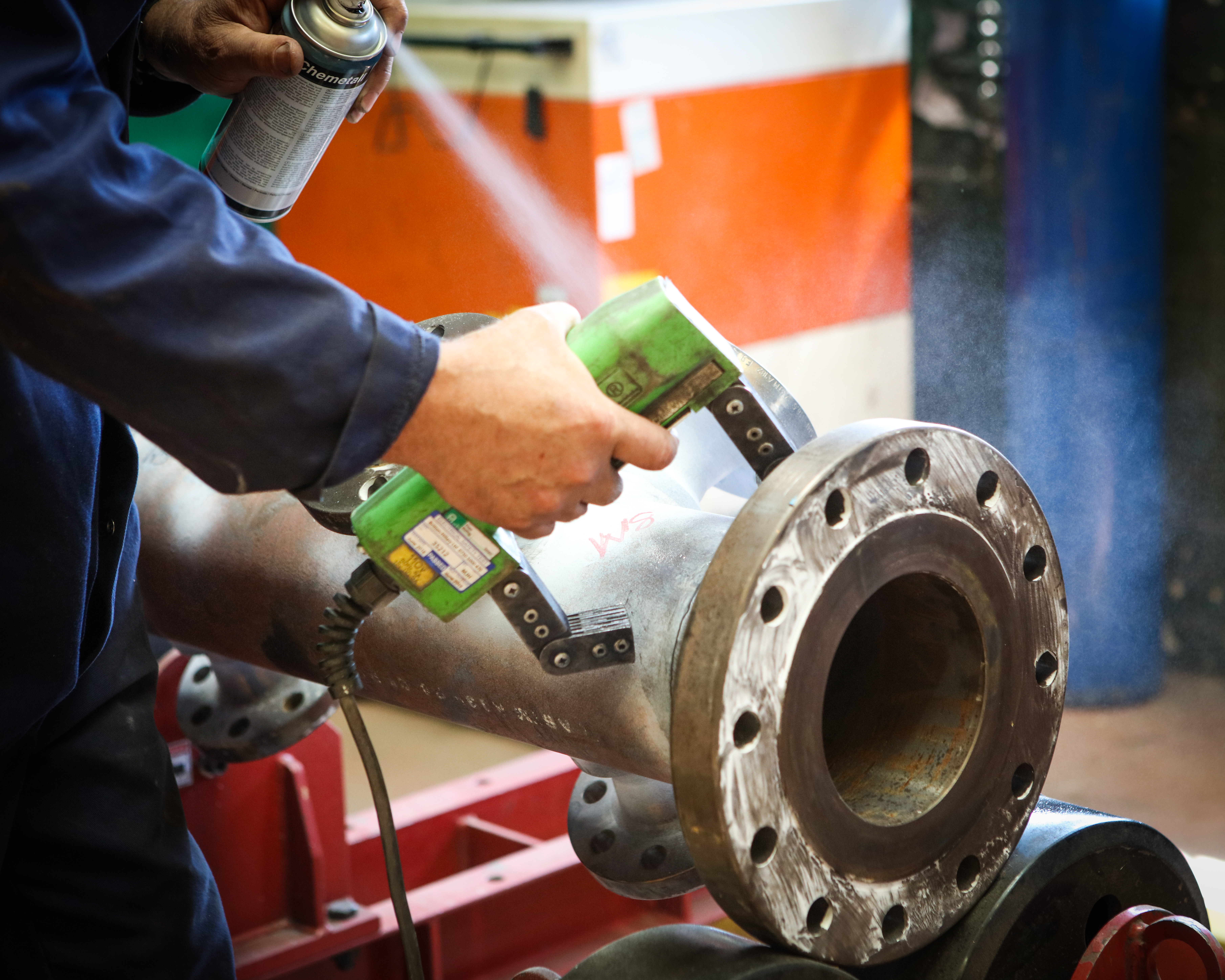 Technician carrying out magnetic particle inspection on industrial equipment