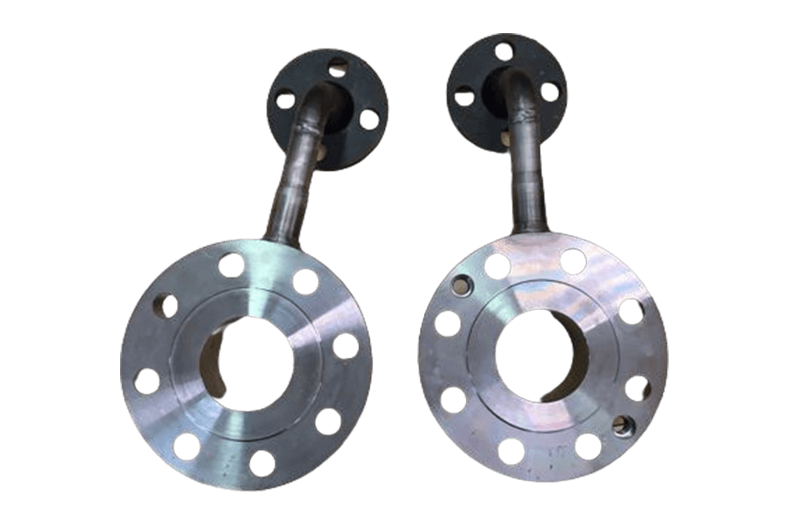 Two metallic orifice plate assemblies with large circular flanged sections and welded pipe connectors