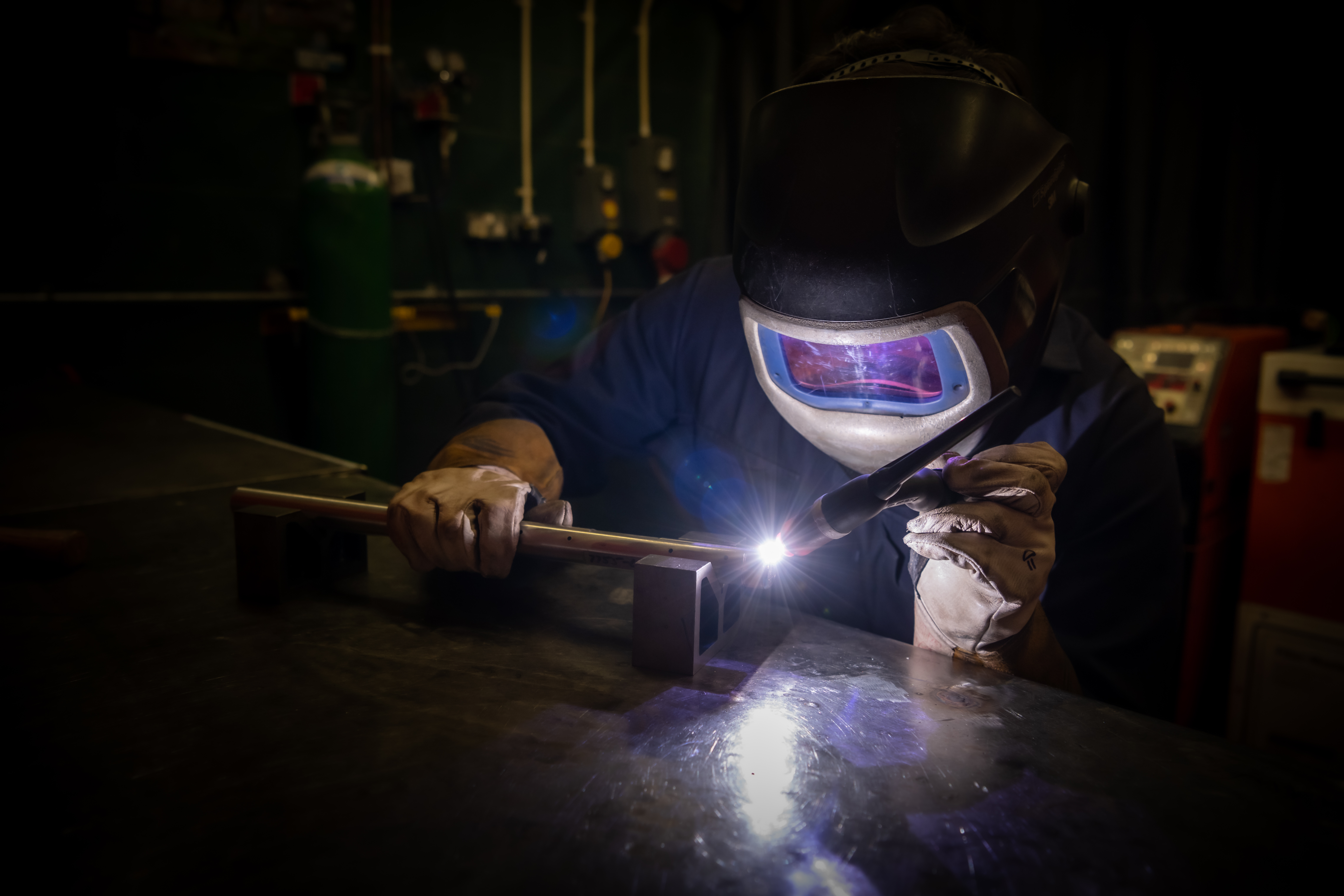 Welder working on industrial pipework